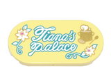 Bright Light Yellow Tile, Round 2 x 4 Oval with White and Gold Flowers and Cooking Pot with Steam, Dark Turquoise Vines, Leaves, and Script 'Tiana's Palace' Pattern